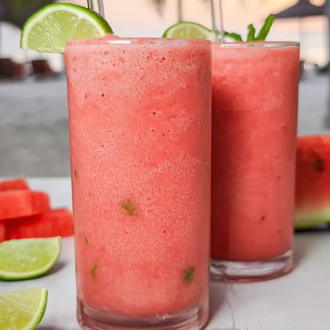 Two glasses filled with bright pink, icy drink.