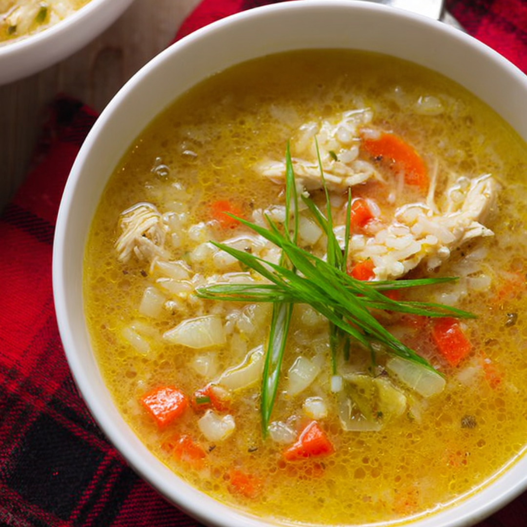 A steaming bowl piled with soup and a sprinkle of green on top.