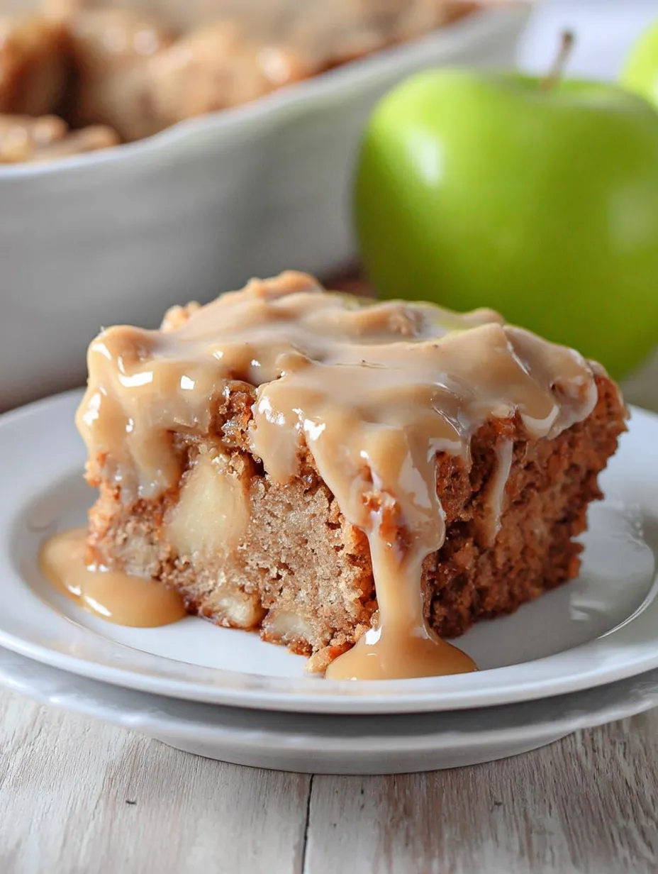 Cake on a white plate with caramel sauce dripping down.