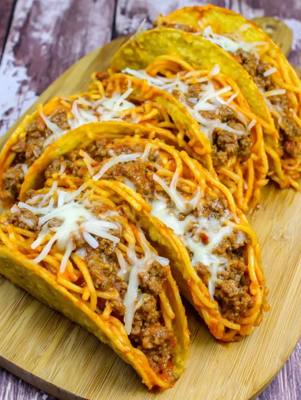 A plate topped with noodles, meaty sauce, and melted cheese.