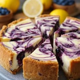A wedge of cheesecake with juicy blueberries and bright lemon.