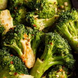 A close up of broccoli with seasoning.