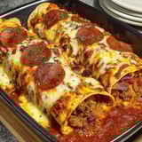 A pan of food with pepperoni and cheese.