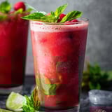 A glass filled with red punch and some mint on top.