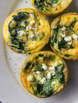 Three spinach and feta muffins on a plate.