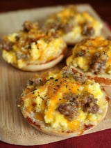 A breakfast pizza with cheese and sausage on top.