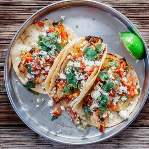 A plate of food with chicken and tomatoes.