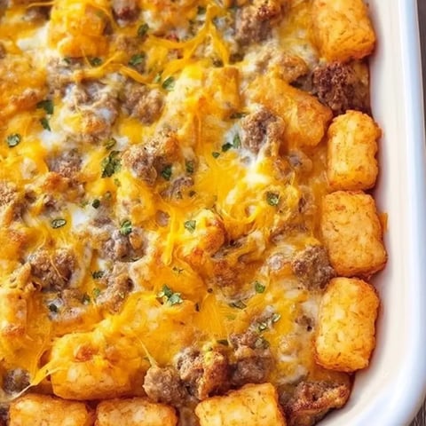A dish of food with a tater tot on top.