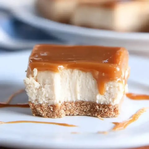 A slice of cheesecake with caramel sauce drizzled on top.