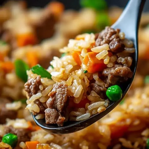 A spoon full of rice and meat.