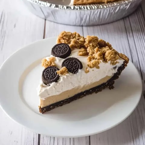 A slice of pie with chocolate and cookie crumbs on top.