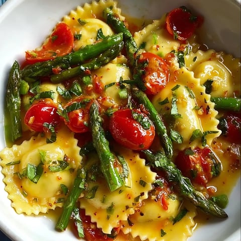 A bright bowl of pasta with tomatoes and asparagus.