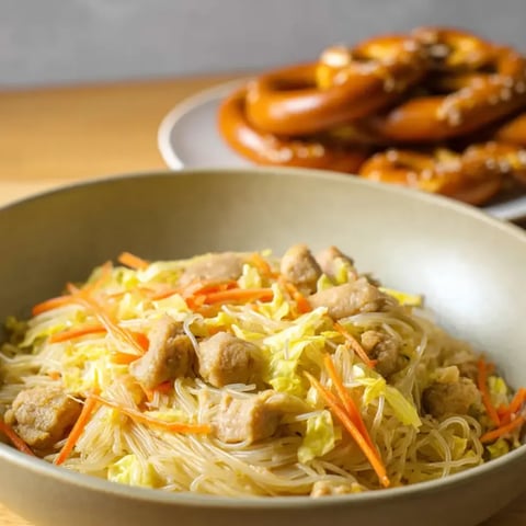 A bowl of noodles with meat and vegetables.