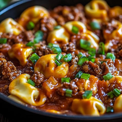 A bowl of pasta with meat and vegetables.