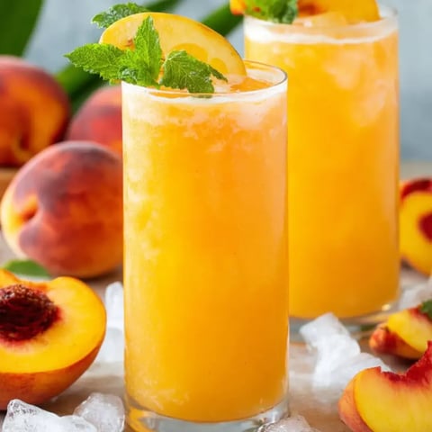 Two glasses of peachy juice topped with mint leaves.
