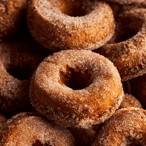 A pile of sugar coated donuts.