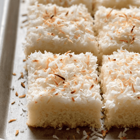 A pan full of coconut sheet cake squares.