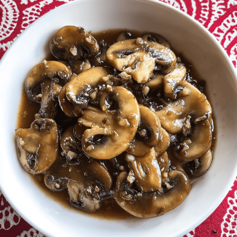 A bowl loaded with saucy mushrooms.