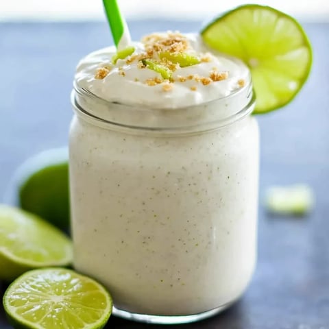 A creamy white drink topped with a lime wedge.