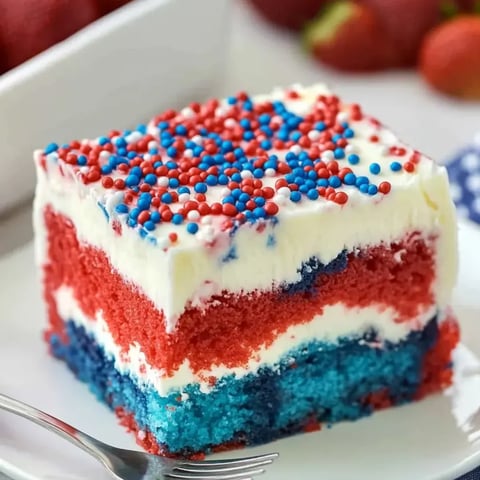 A slice showing red, white, and blue cake with whipped topping.