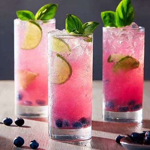 Pink drinks with berries in three glasses.