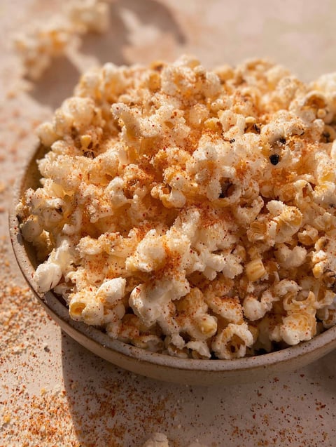 A bowl of popcorn with garlic and Parmesan cheese.