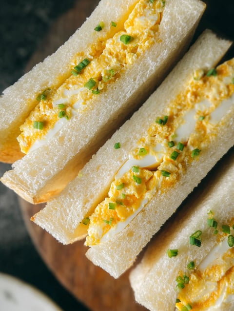 A Japanese egg sandwich with green onions.